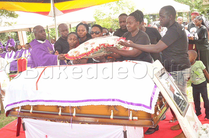 Abooluganda nga bakulembeddwamu Fr.Ssekabira mukulu w'omugenzi nga baganzika ekimuli ku Ssanduuke.
