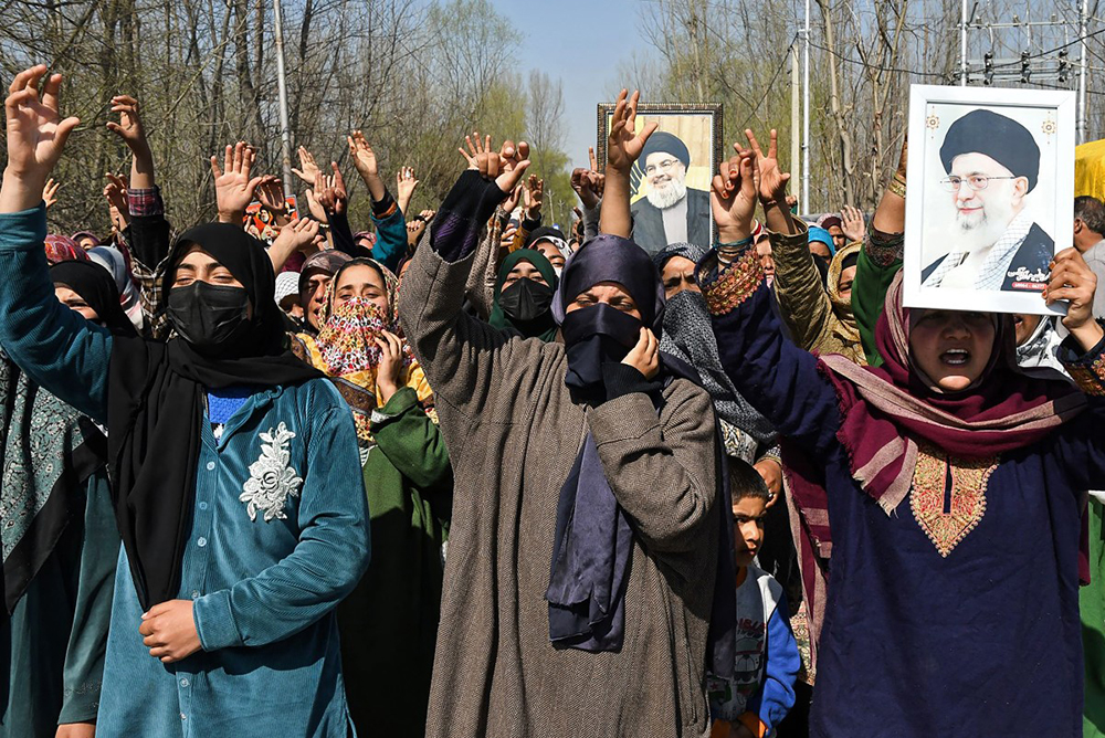 Shia Muslim women hold portraits of Iran's late supreme leader Ayatollah Ali Khamenei (R) and Lebanese group Hezbollah's late leader Hassan Nasrallah during an anti-US-Israel protest at Sumbal in Bandipora district on March 3, 2026. (AFP)