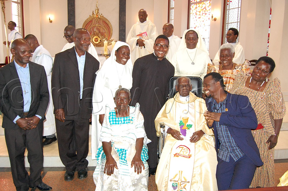 Msgr. Joseph Mugambe (seated) shares a photo moment with family members during the thanksgiving mass for his 100th birthday and 70th priestly anniversary at Christ the King Church Kampala on Sunsday November 23, 2025. (Photo by Mathias Mazinga)