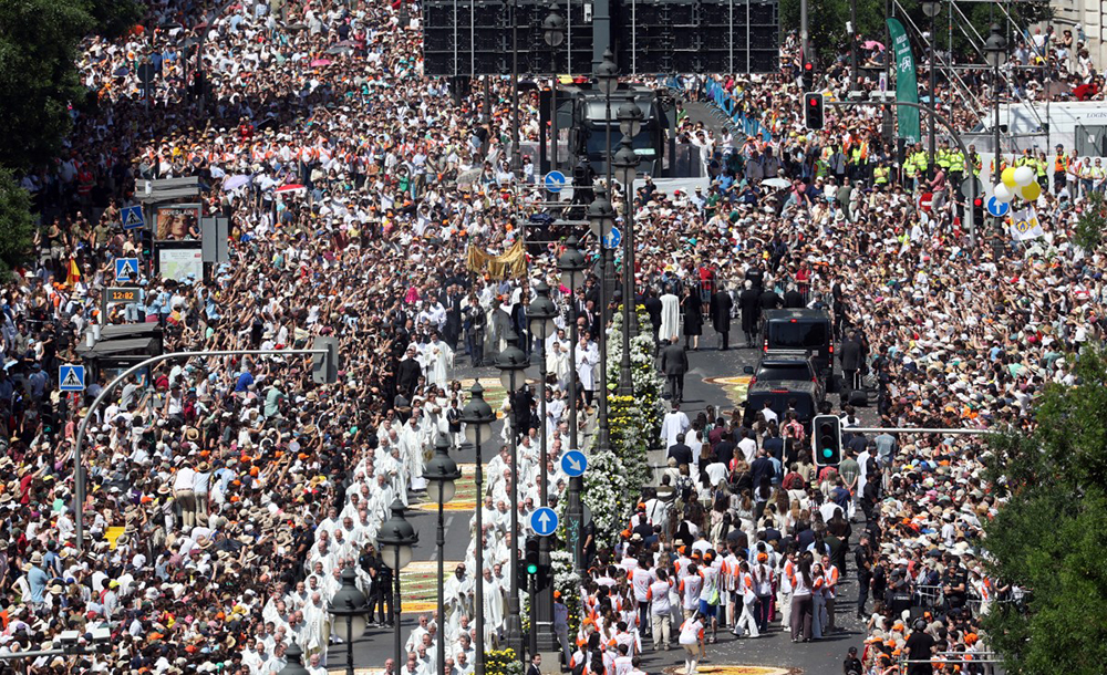 The crowd packs Alcala street as Pope Leo XIV walks under a processional canopy holding the monstrance containing the sacred host during the Corpus Christi procession following the Holy Mass held in the Plaza de Cibeles in Madrid on June 7, 2026.