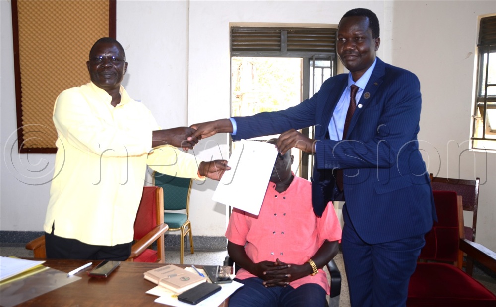 Teso affairs state minister Dr Kenneth Clement Ongalo Obote handing over the VP Alupo's speech to Dr Opul Joseph during the handover of the wheelchairs to PWDs in Katakwi on Friday, July 10, 2026.