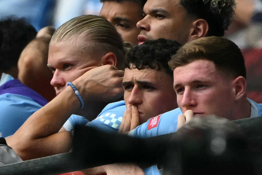 Manchester City's Norwegian striker #09 Erling Haaland (L), Manchester City's English midfielder #47 Phil Foden (C) and Manchester City's English midfielder #05 Elliot Anderson (R) look on from their seats after being substituted during the English FA Community Shield football match between Arsenal and Manchester City at The Principality Stadium, in Cardiff, south Wales on August 16, 2026.