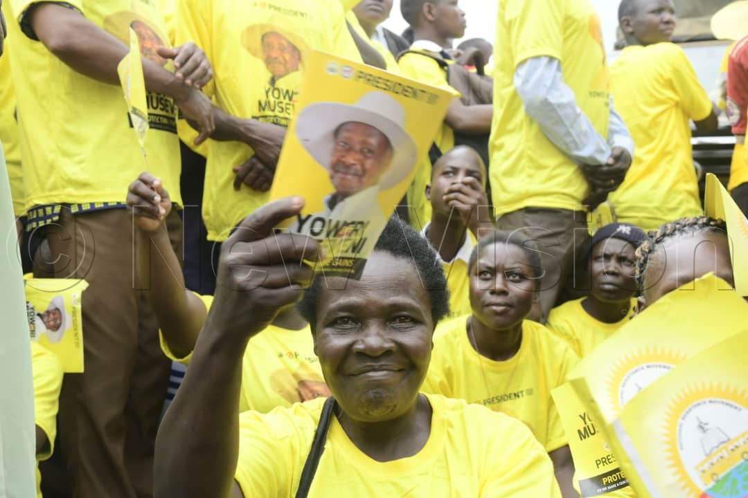 An NRM supporter waving President Museveni's campaign flyer.