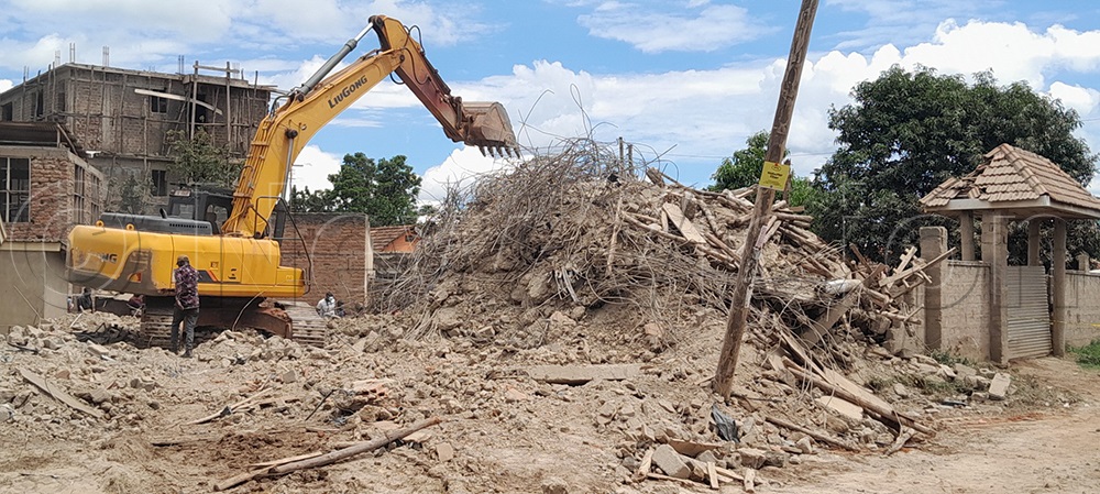 An excavator removes the rubble in search of the suspected eight that are still missing in the collapsed four-storey building in Mbale City. (Credit: Paul Watala)