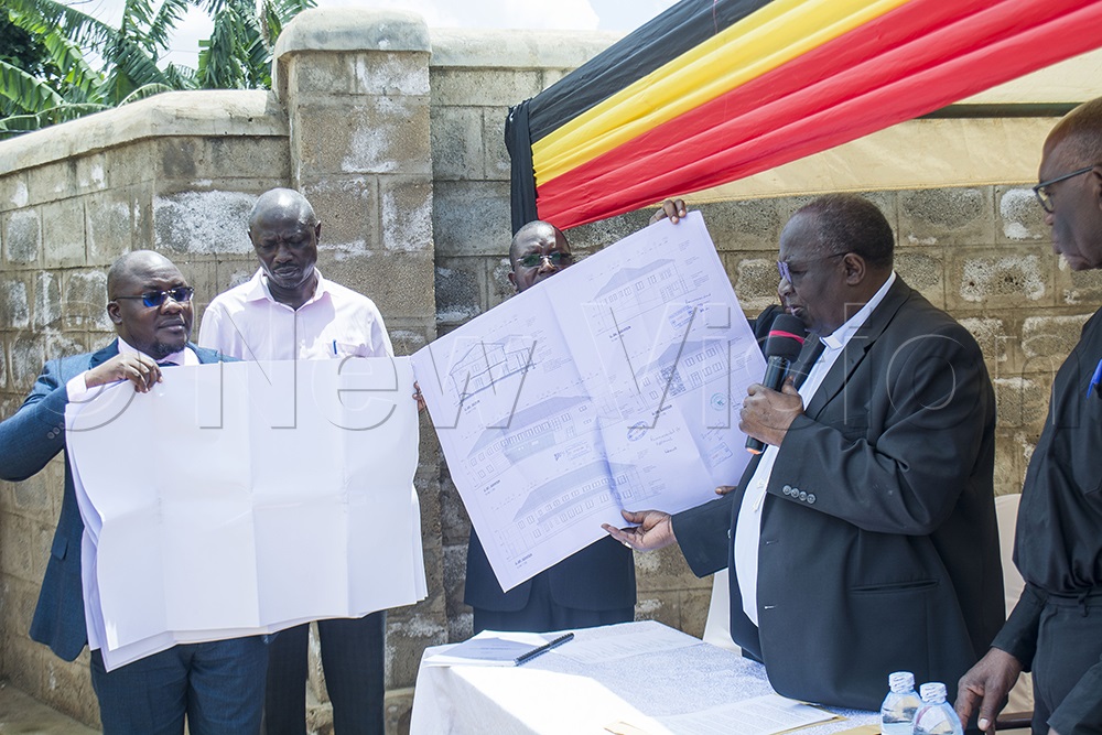 The Archbishop handing over the structure plan to JMS, who are to execute the construction of sh1.9 billion facility. (Photo by George Ofwono)