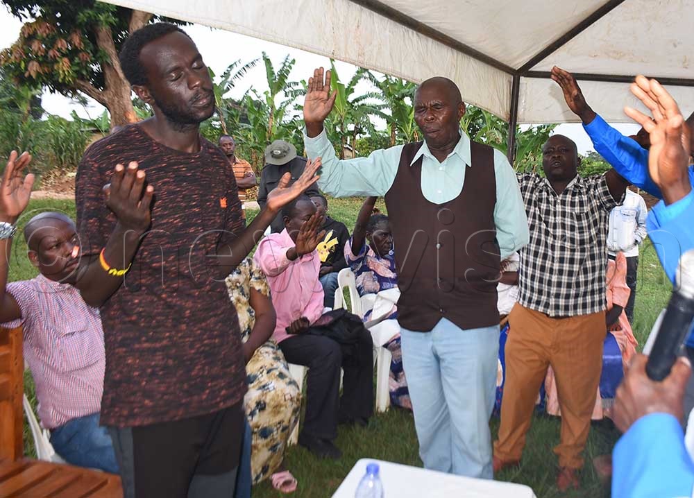 Eria Mubiru's supporters pray for him. (Credit: Luke Kagiri)