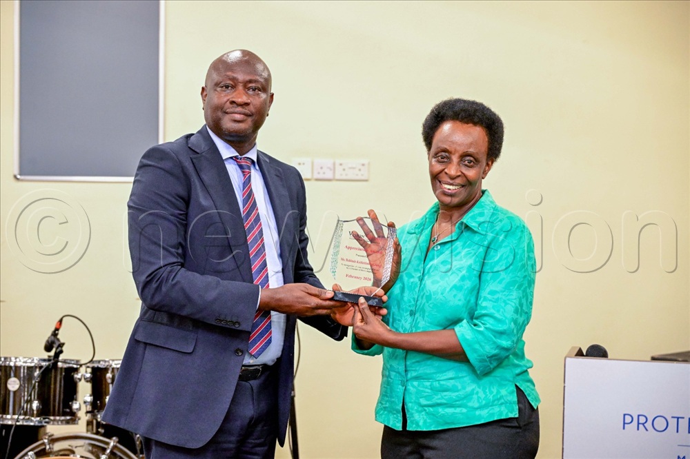 Vision Group board chairperson Dr Edward Damulira Sengonzi(left) with outgoing non-executive director Robinah Kaitiritimba.