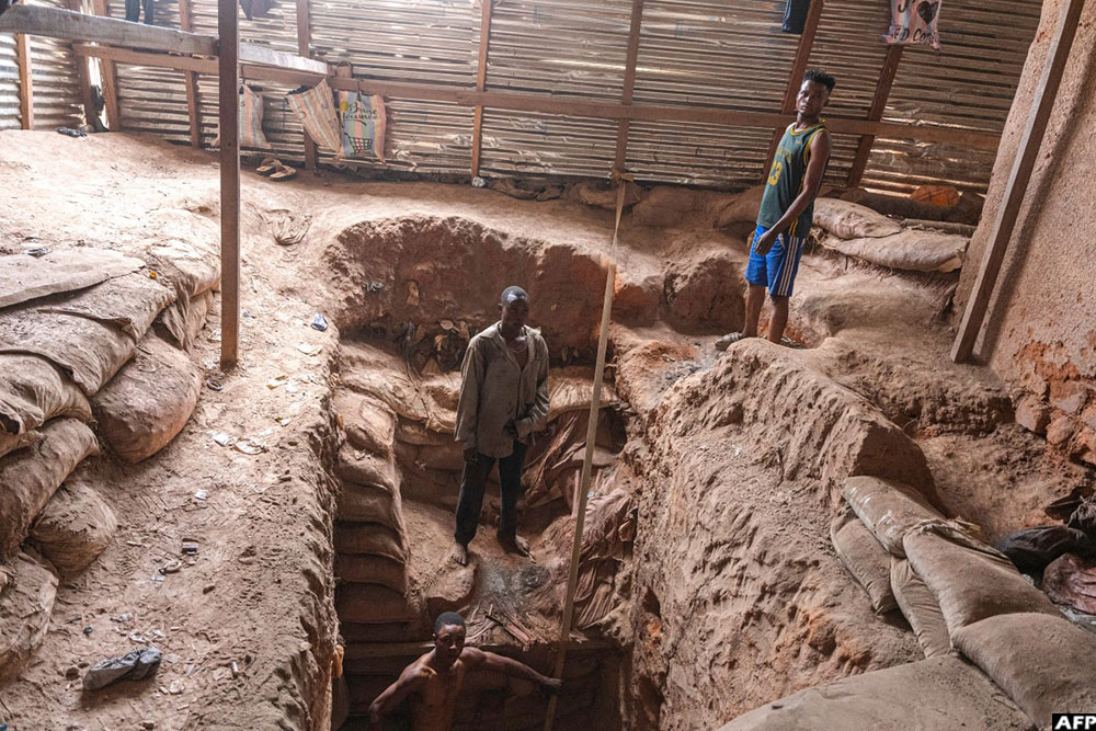 Artisanal miners wait for bags of copper ore to be brought to surface from the 110-metre-deep mine shaft in Kolwezi