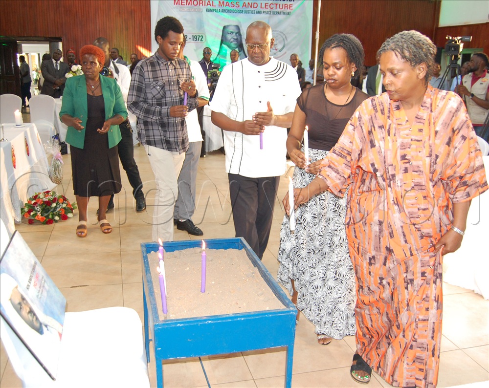 The family members led by Maxensia Zalwango Kiwanuka proceed to light memorial candles.