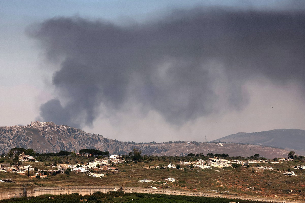 This picture taken from a position in the Upper Galilee in northern Israel, near the Israel-Lebanon border on June 17, 2026, shows destroyed buildings and smoke billowing in the distance behind the medieval Beaufort Castle (L) in southern Lebanon, known locally as Qalaat al-Shaqif or Shaqif Arnoun, that was captured by Israeli forces last month. (Photo by JACK GUEZ / AFP)