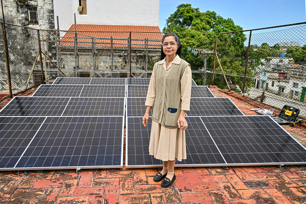Sister Gertrudis poses in front of a new photovoltaic system installed in a senior dining hall run by the Catholic Church in the Guanabacoa neighborhood of Havana on February 4, 2026.  (Credit: AFP)