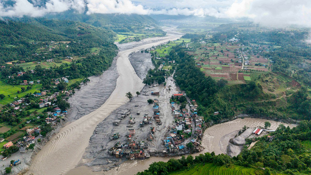 An aerial view shows houses lying deluged in sludge after flash floods at Devighat, Bidur Municipality, along the confluence of the Trishuli and Tadi rivers in Nepal's Nuwakot district on August 27, 2026.