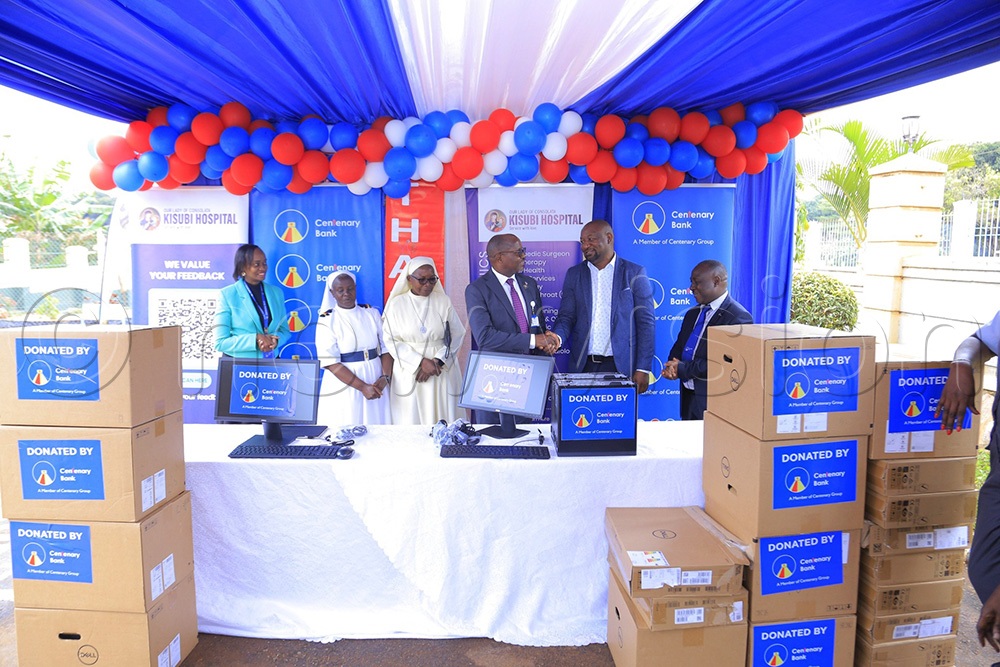 The centenary Managing Director, Fabian Kasi (middle) who was accompanied by Kawuku manager, Joseph Nsubuga (last on right) handed over the computers to the Medical Director Dr. Robert Asaba (2nd on right) together with the other management officials (SISTERS) as Chief Manager of Corporate Affairs and Communications at Centenary Bank Allen Ayebare looks on, on Tuesday December 16, 2025. (Photo by Juliet Anna Lukwago)