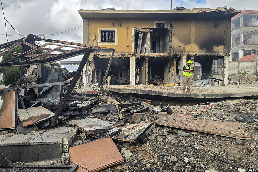 A first responder works at the site of an Israeli airstrike in the southern Lebanese village of Hanouiyeh, east of Tyre, on March 30, 2026. (AFP)