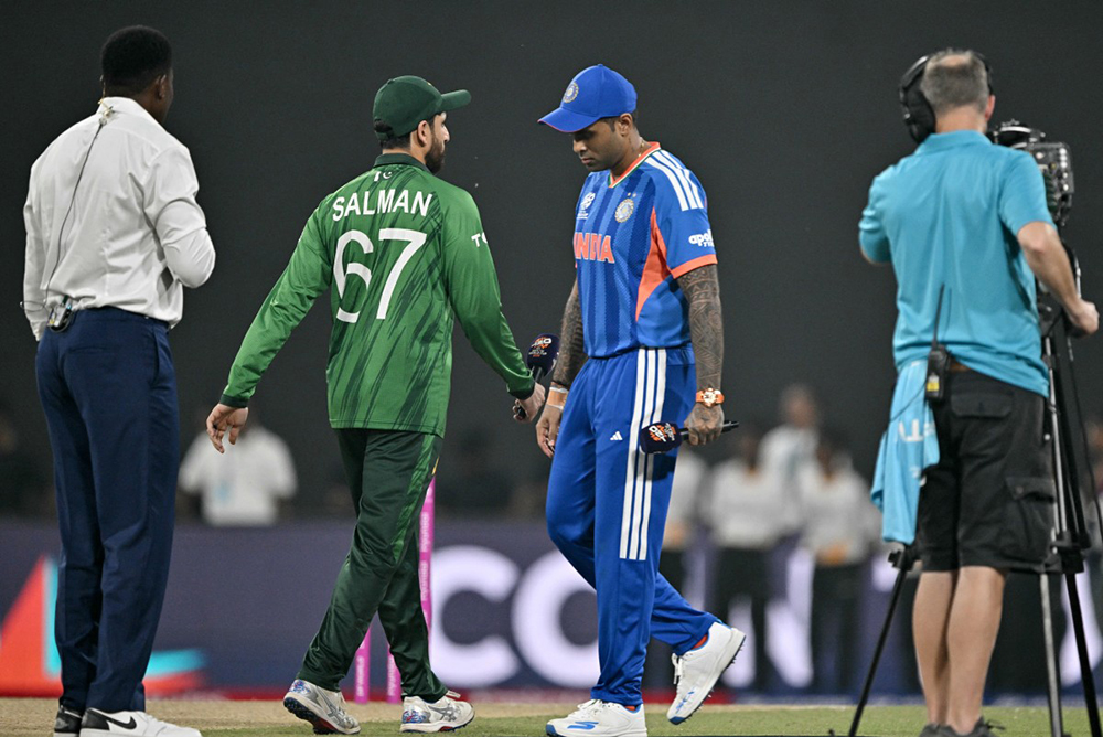 India's captain Suryakumar Yadav (2R) walks past his Pakistan counterpart Salman Agha (2L) after the toss before the start of the 2026 ICC Men's T20 Cricket World Cup group stage match between India and Pakistan at the R Premadasa Stadium in Colombo on February 15, 2026. 