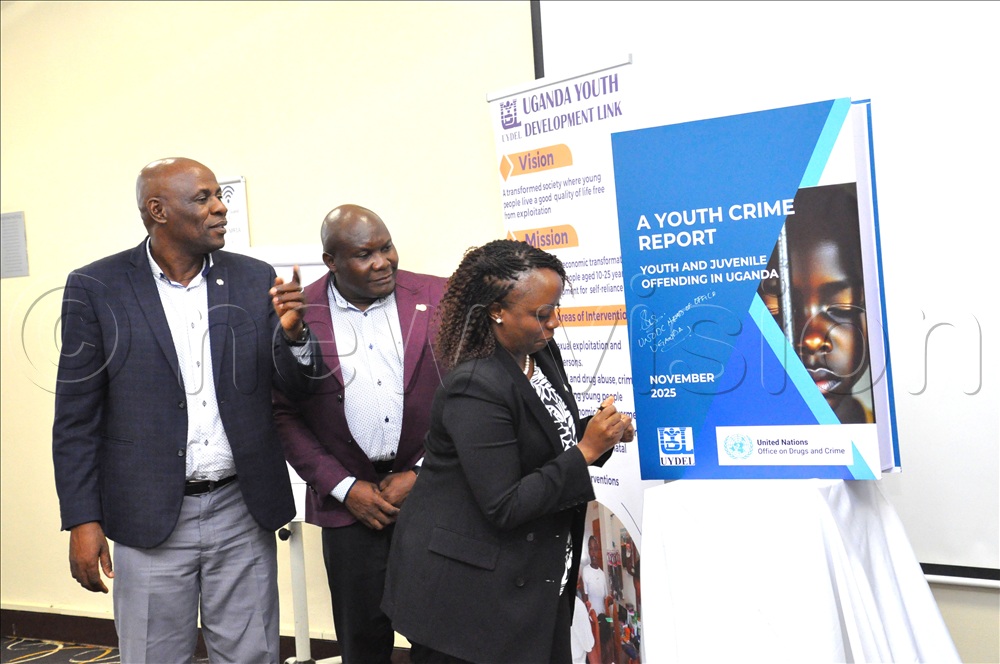 (L-R) Rogers Kasirye Executive Director UYDEL and Rogers Mutaawe Senior Programme Manager UYDEL look on as Sharon Nyambe Head of Office United Nation Office of Drugs and Crime (UNODC) appends a signature on the dummy report. This was during the launch of the Youth Crime Report at Protec Hotel Kampala on November 26, 2025.