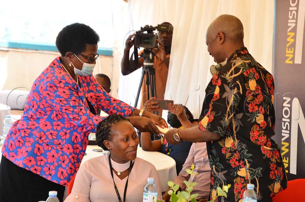 Senior Producer Hellen Mukiibi, handing over a gift to her outgoing boss Kakande.