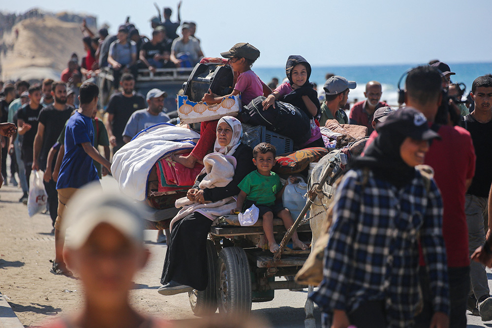 Palestinians make their way along Al-Rashid road toward Gaza City from Nuseirat in the central Gaza Strip on October 10, 2025. Israeli forces declared a ceasefire and withdrew from some positions in Gaza on October 10, as thousands of displaced Palestinians began to trek home and the families of October 7 hostages awaited news. (Photo by Bashar TALEB / AFP)