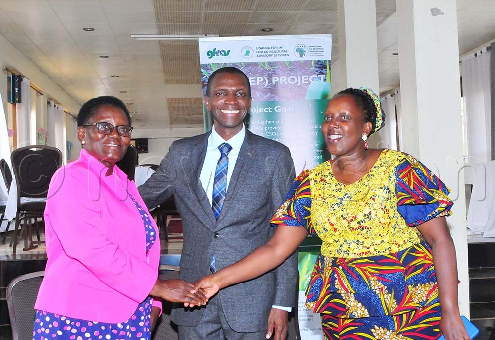 Roselline Kabasiita Nyamutale (L), The Vice Chairperson Uganda Forum for Agricultural Advisory Services shakes hands with Adeline Muheebwa (R), the outgoing Chairperson as Dr Richard Miiro (C), the incoming Chairperson Uganda Forum for Agricultural Advisory Services looks on during a partners strategic meeting on March 11, 2025. (Credit: Nicholas Oneal)