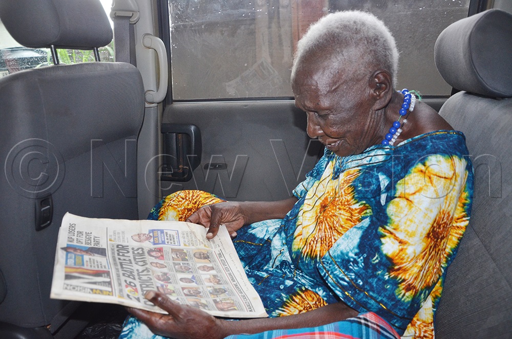 Maama Christina Nyafwono Oburu, 100 years, reads the New Vision Paper. (Photo by Juliet Anna Lukwago)