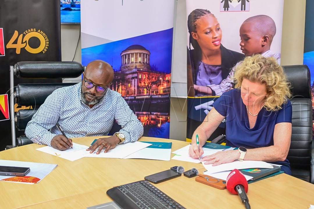 Vision Group CEO Don Wanyama (left) and Ireland's Ambassador to Uganda, Mags Gaynor (right), sign a Memorandum of Understanding (MoU). (Credit: Miriam Namutebi)