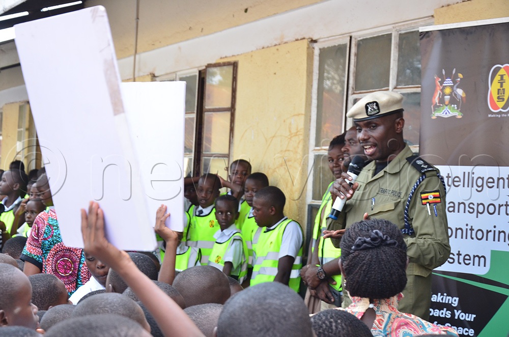 Traffic police spokesperson Michael Kananura addressing pupils at Buhinga Primary school. (Photo by Jonan Tusingwire)