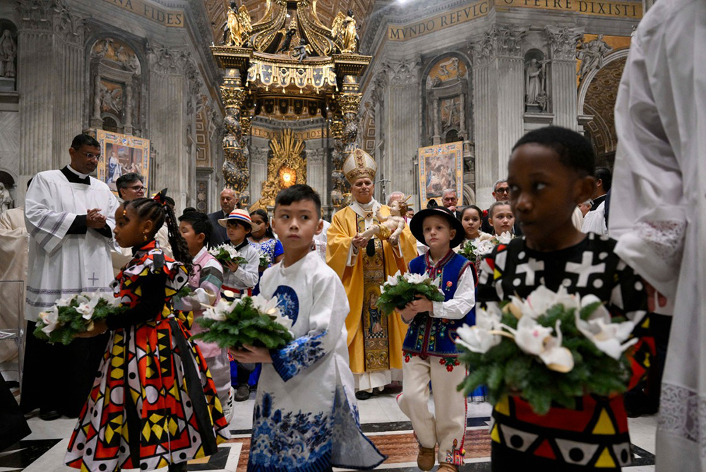Pope Leo XIV carrying the statue of Baby Jesus at the end of the Christmas Eve mass at St. Peter's Basilica at the Vatican. (Photo by Simone Risoluti / VATICAN MEDIA / AFP)