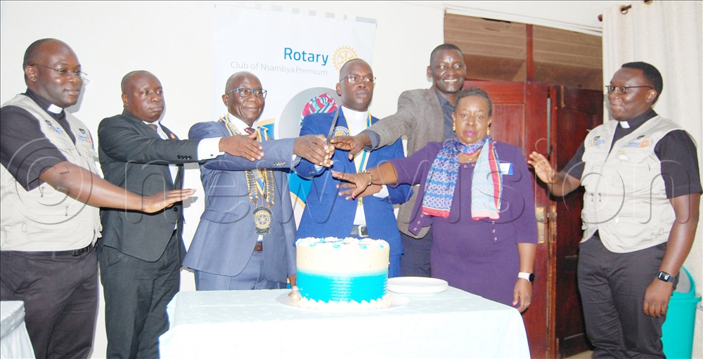 Rotary Governor Daniel Ddamulira Mukasa (third-left), cuts cake with the President of the Rotary Club Nsambya Premium, Fr. Pontian Mayega (fourth-left), Rotarian Rita Baraka (second-left), Rotarian Yusuf Kigoye (third-left) , Rtn Fr. Simon Peter Ssekyanzi (left) and Rtn. Fr. Honoratus Kazibwe (right). This was during the weekly fellowship of the Rotary Club of Nsambya Premium at Cardinal Nsubuga Leadership Trainng Centre Nsambya on Wednesday, July 15, 2026.