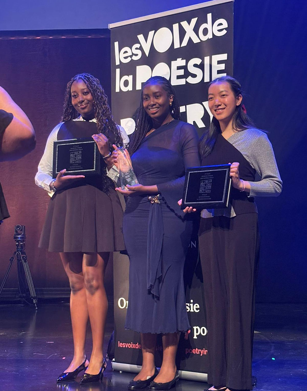 Cianna Rukundo Namakula (C), a student at École secondaire Étienne-Brûlé, a French-language secondary school in Toronto, Ontario, emerged as the 2026 national champion of the Poetry in Voice/Les Voix de la Poésie competition after excelling in the bilingual category, where participants recite poetry in both English and French.