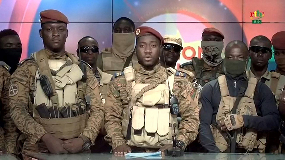 This video grab taken from a video broadcasted on October 2, 2022 by the national television of Burkina Faso shows Captain Kiswendsida Farouk Azaria Sorgho (C), member of the junta reading a statement next to Coup leader Ibrahim Traor&eacute; (L) and surrounded by members of the military after they took power on September 30, 2022 in Ouagadougou. 