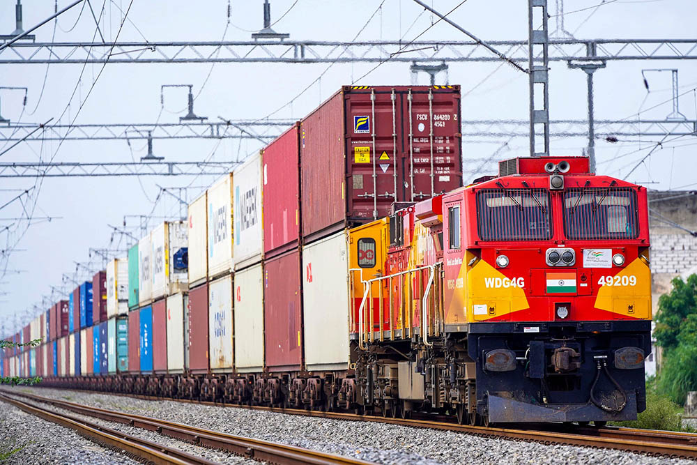 A freight train carrying cargo containers rides along a railway track in Ajmer on August 26, 2025. US President Donald Trump has threatened to double import duties on India from 25 to 50 percent by August 27, to punish New Delhi for buying oil from Russia, saying the purchases help Moscow fund its invasion of Ukraine.. (Credit: AFP)