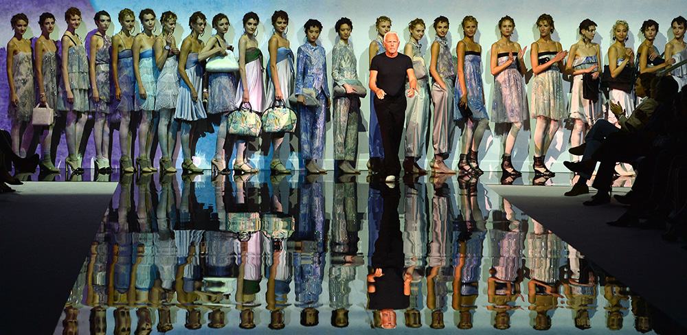 Italian designer Giorgio Armani acknowledges the applause of the audience at the end of his show for fashion house Emporio Armani as part of the spring/summer 2014 ready-to-wear collections during the fashion week in Milan on September 20, 2013. (Photo by Giuseppe CACACE / AFP)