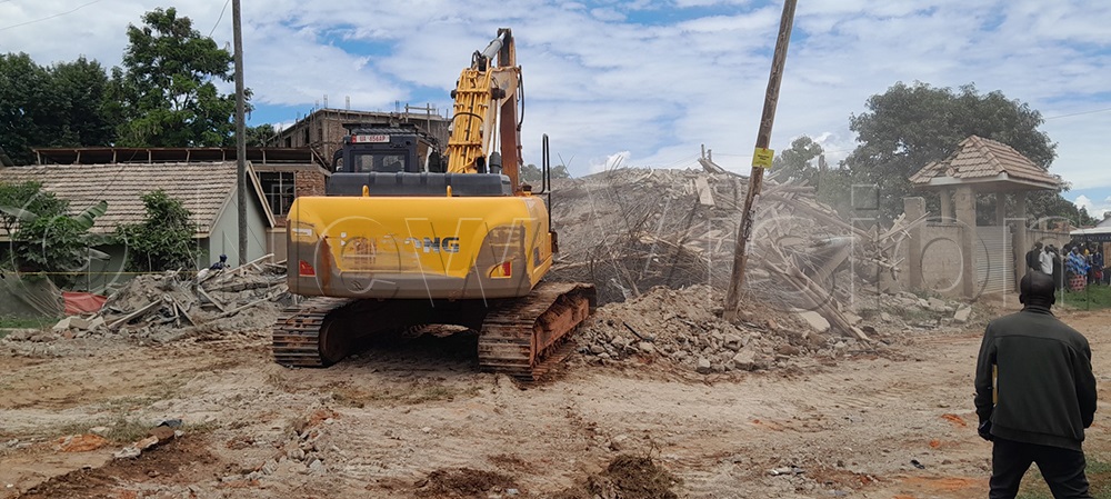 Residents looking on as the excavator tries to remove the rubble in search of the survivors covered in the collapsed building in Namakwekwe, Northern city division, Mbale City. (Credit: Paul Watala)