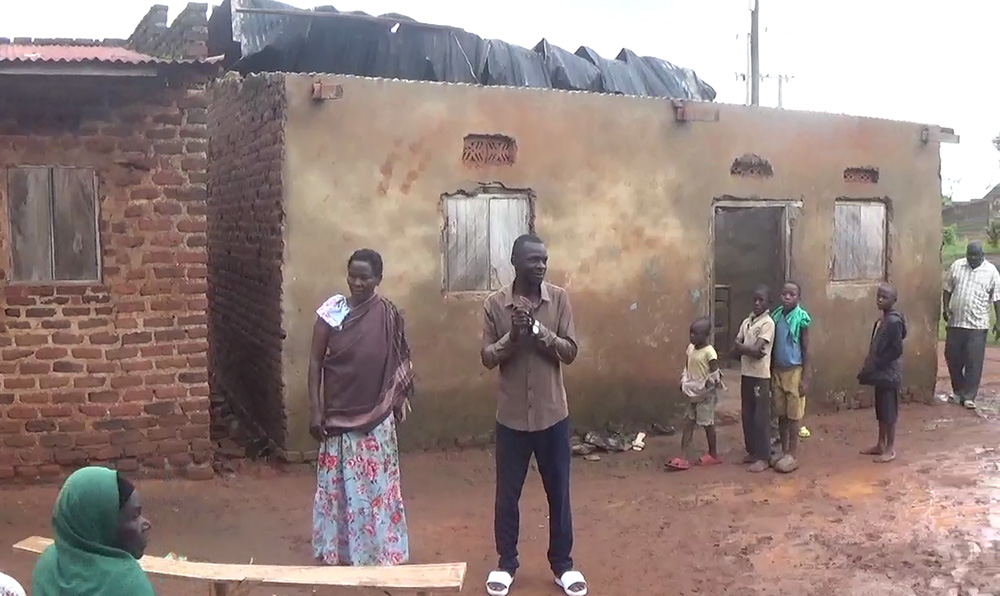 Prossy Naigwe one of the victims (L) and whose house roof top was blown off, standing with others in front of the house. (Photo by Ivan Wakibi)