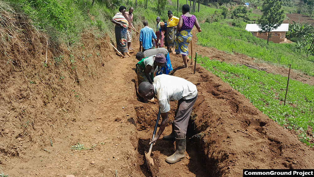 Community members digging trenches to prevent soil erosion in the hilly terrain