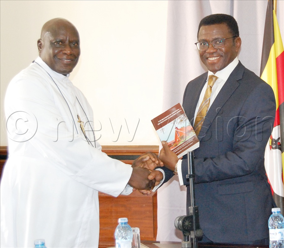 Bro. Casio Aizire gifts Katikkiro Charles Peter Mayiga with a book about the history of the Brothers of Christian Instruction in Uganda, during the meeting. This was during the visit of the Brothers to the Katikkiro at Bulange Mengo on Friday, August 7, 2026.