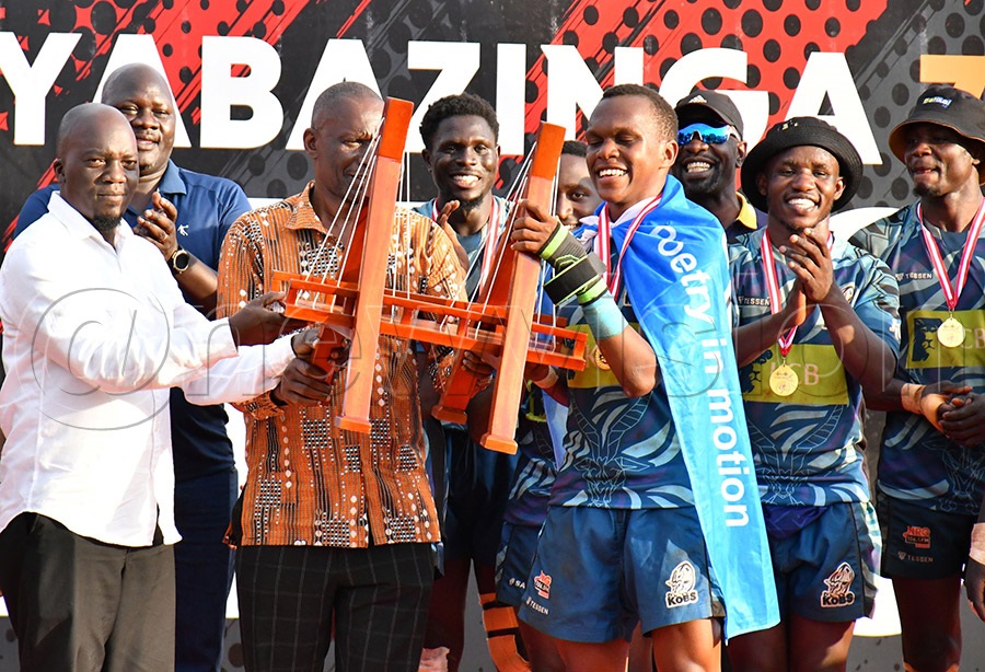 The Chief Prince (Issabalangira) of Busoga Samuel Zirabamuzale Nkuutu (left) handing over the trophy to KCB Kobs captain after emerging champions of the Kyabazinga 7s at Kyabazinga Stadium in Bugembe. Photo by Donald Kiirya