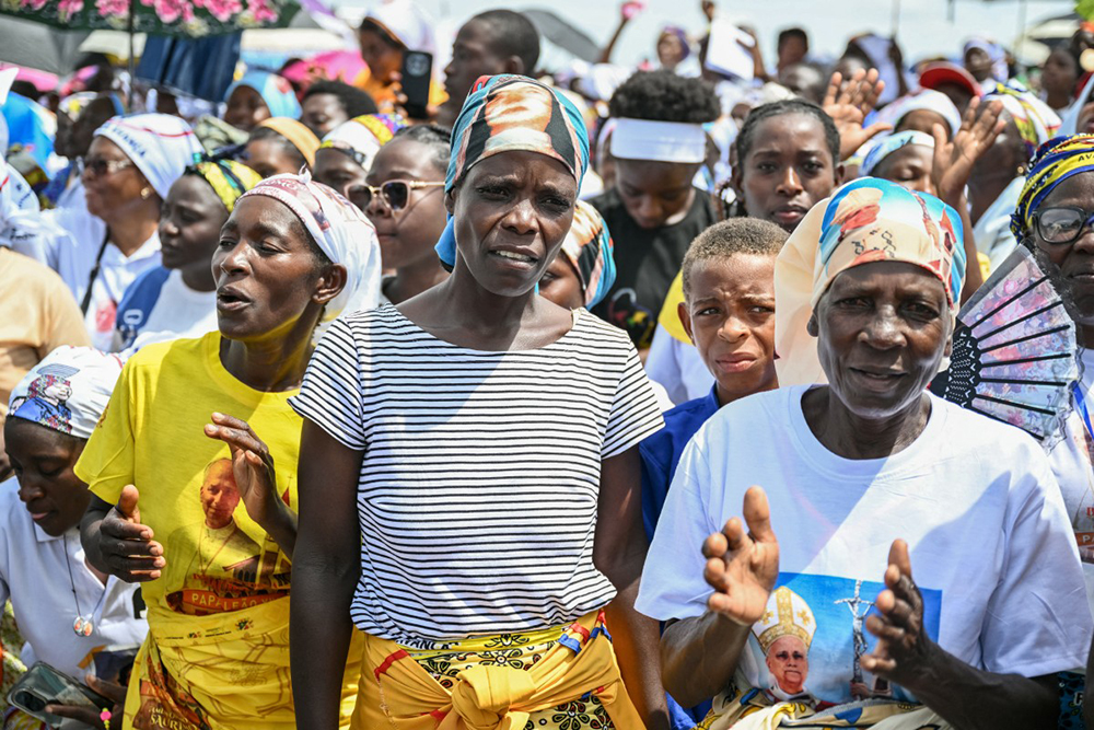 Faithfuls sing as they gather ahead of Pope Leo XIV's Holy Mass at the Saurimo esplanade in Saurimo on the eighth day of an 11-day apostolic journey to Africa, on April 20, 2026. 