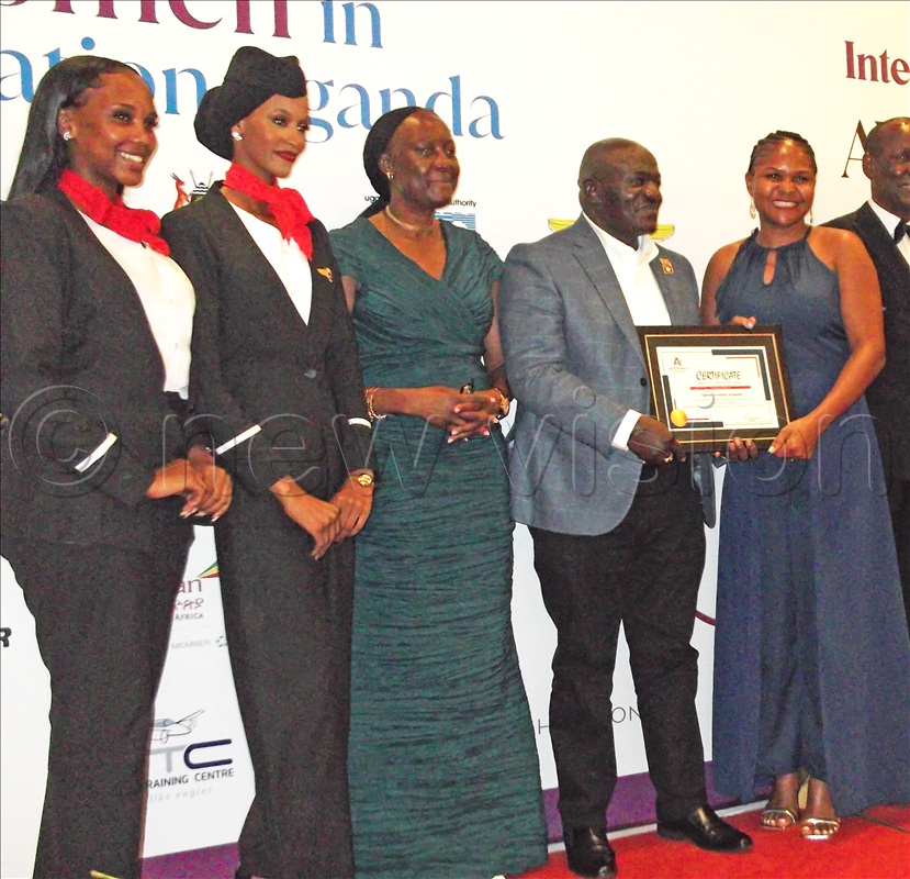 (From left to right); Some of the crew aviation members Olive Birungi Lumonya of (UCAA) and Gen. Edward Katumba Wamala, awarding aviation member. 