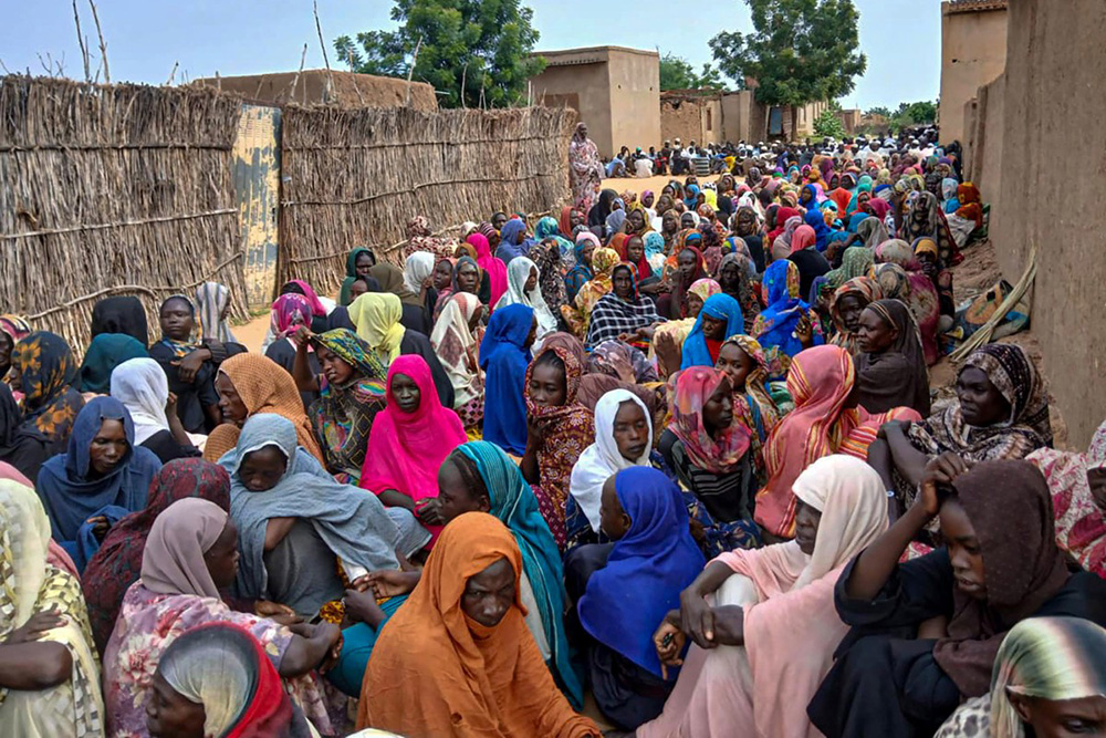 Sudanese residents gather to receive free meals in Al Fasher, a city besieged by Sudan's paramilitary Rapid Support Forces (RSF) for more than a year, in Darfur region, on August 11, 2025. (Photo by AFP)