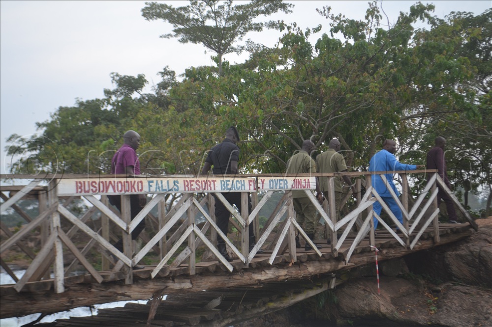 A team of securty officers accessing the woodon bridge at Busowoko falls resort beach in Jinja district. 