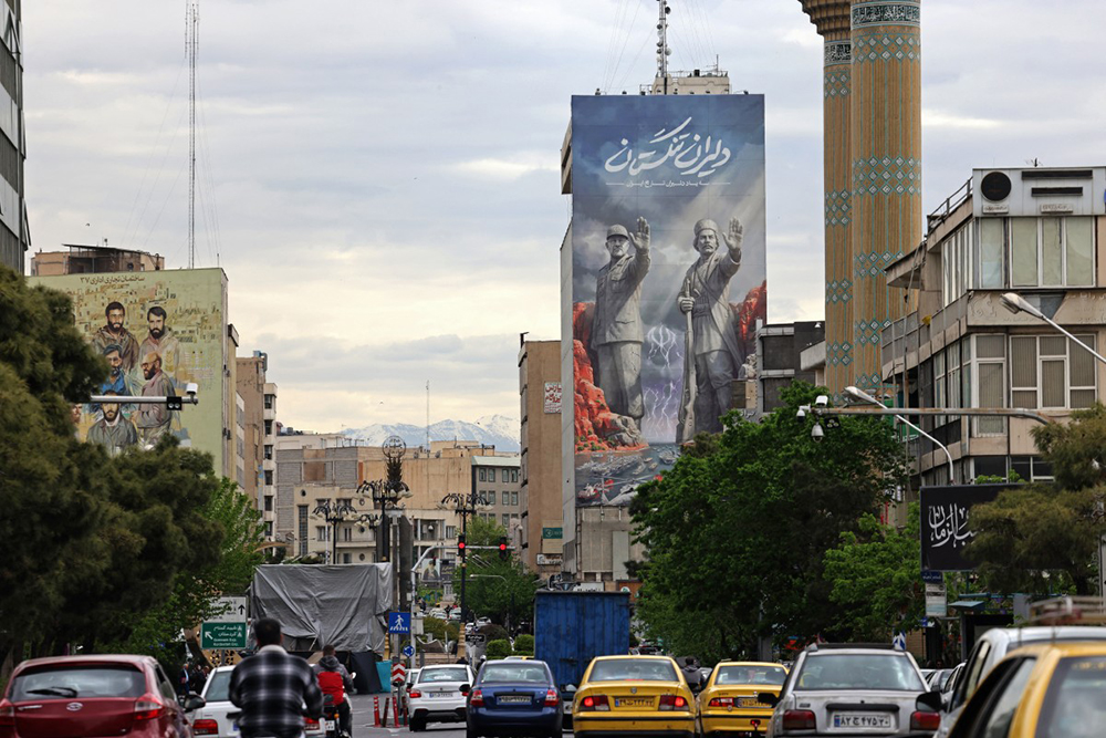 Commuters drive past a giant billboard referring to the 'Strait of Hormuz' along a busy street in Tehran on April 19, 2026. (Credit: AFP)