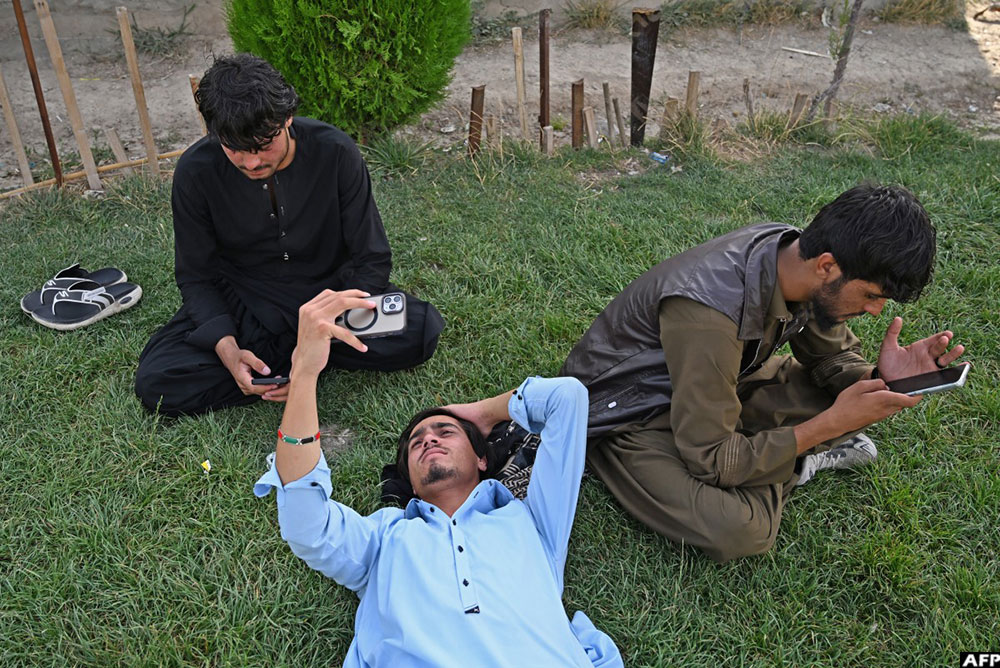 Afghan youths use their smartphones at the Wazir Akbar Khan hilltop in Kabul