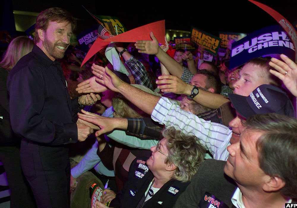 Actor Chuck Norris works the crowd to campaign for US Republican Presidential candidate Texas Governor George W. Bush during a rally of approximately 7,000 people inside the City of Fresno Convention Centre on October 30, 2000