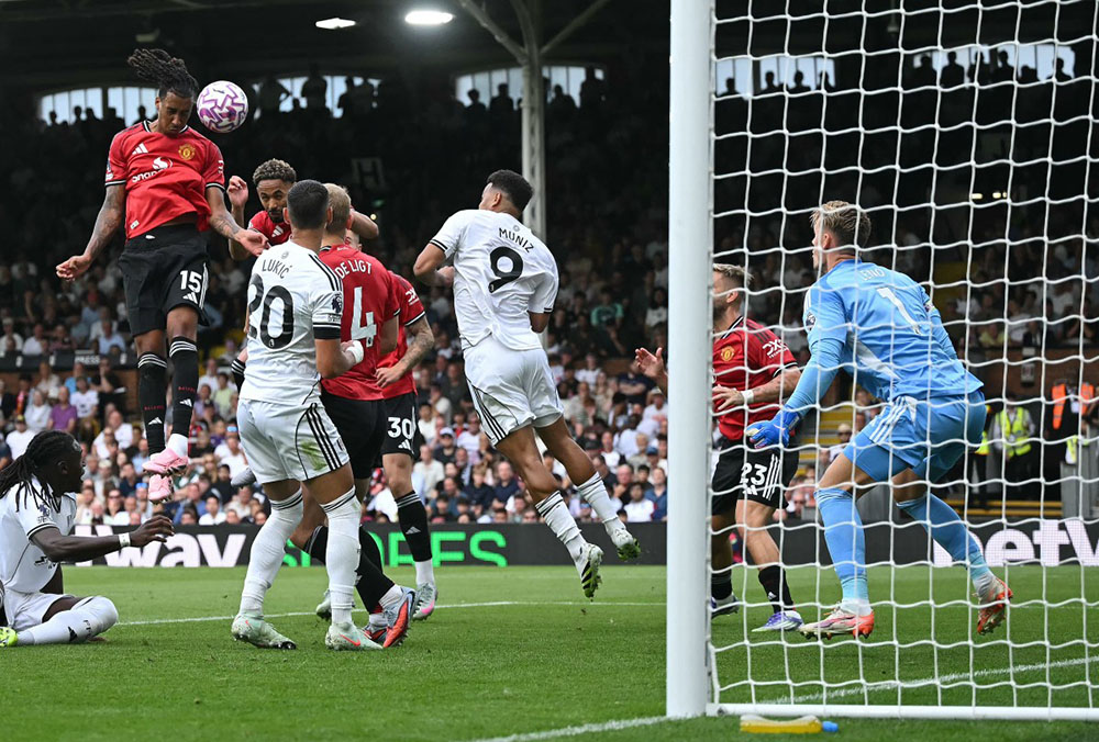 Manchester United's French defender #15 Leny Yoro (L) headers the ball to score the opening goal during the English Premier League football match between Fulham and Manchester United at Craven Cottage in London on August 24, 2025. (Credit: AFP)