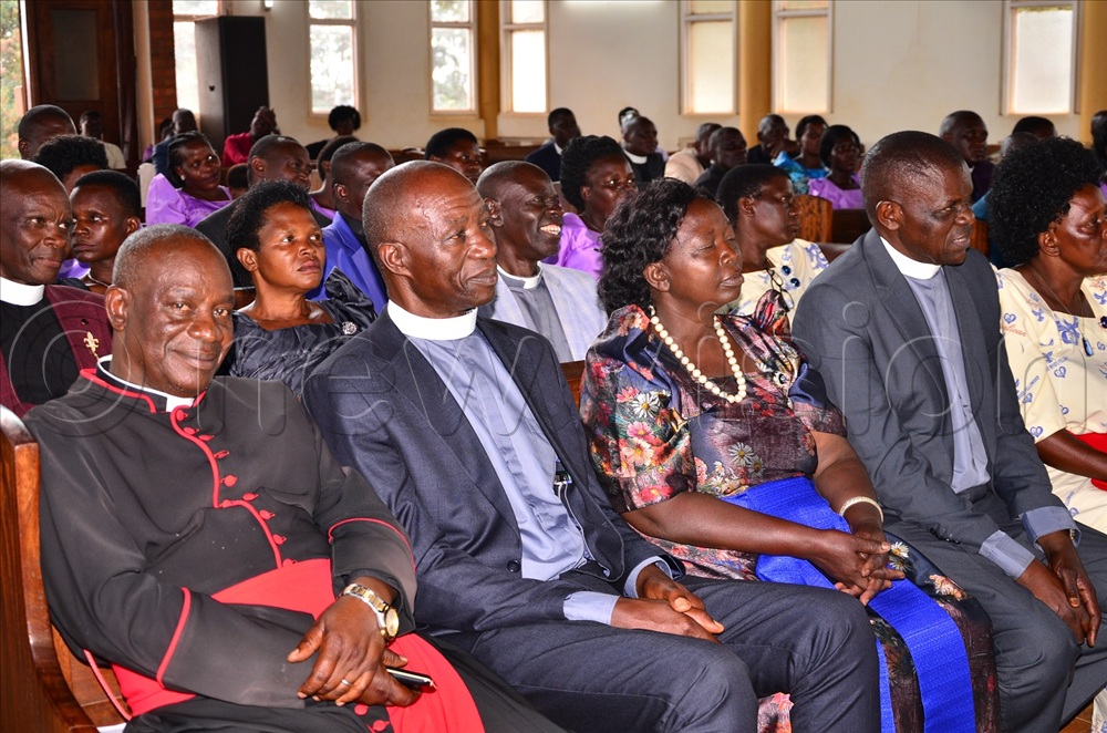 Can. Moses Kisule (L), the chairperson of archdeacons, flanked by Irongo and other clergies with their spouses as they bid farewell to Naimanhye at the Cathedral on Tuesday.
