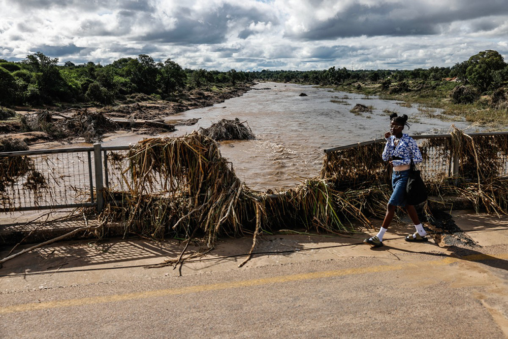A young girl walks across the damaged bridge crossing the Ga-Selati River, just outside Phalaborwa on January 16, 2026 following heavy rains over much of the Limpopo Province, South Africa. (Photo by Paul Botes / AFP)