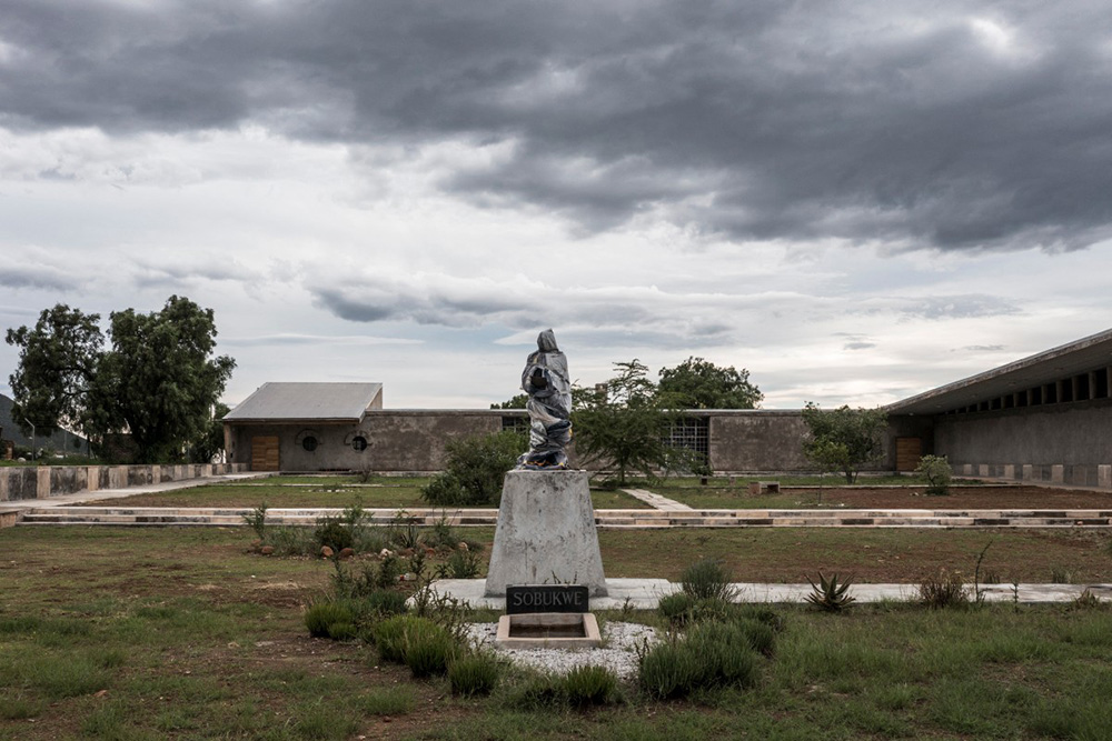 The wrapped statue of the late Robert Sobukwe, the anti-apartheid leader and founding member of the Pan Africanist Congress (PAC) is seen through a fence of the Sobukwe Museum and Learning Centre in Graaff-Reinet, on March 5, 2026.  (Photo by MARCO LONGARI / AFP)