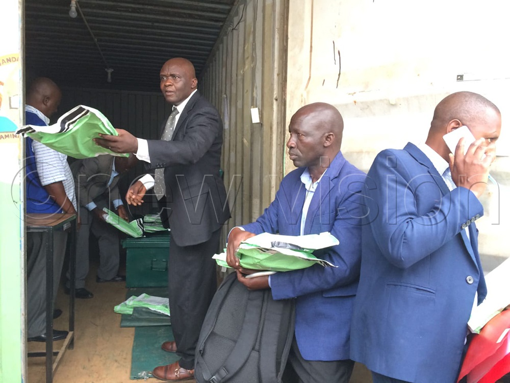 Godfrey Birungi, Uganda National Examinations Board (UNEB) Mbarara City area supervisor and coordinator, distributes examination materials to head teachers in Mbarara City. (Credit: Abdulkarim Ssengendo)