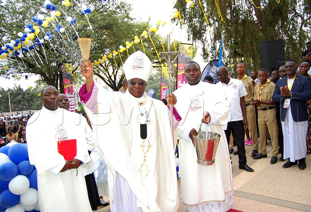 The Archbishop of Kampala Archdiocese, Paul Ssemogerere (wearing a mitre) sprinkles holy water on the Catholic faithful during the processison of the Pontifical mass for the celebration of the centenary of Rubaga Cathedral on  Sunday, October 26, 2025. (Photo by Mathias Mazinga)